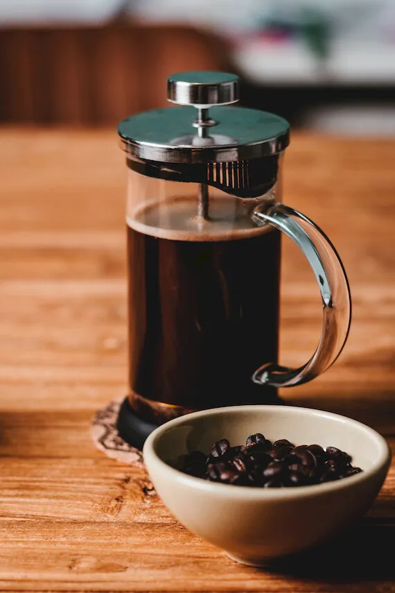 Zaparzacz French Press stoi na stole kolo filizanki